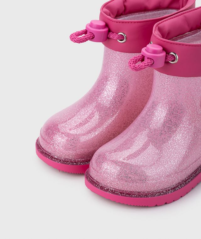 A girls wellie by Igor, style Bimbi Unocornio, in pink glitter with unicorn detail. Toggle fastening. Close up of left side angled view of a pair.