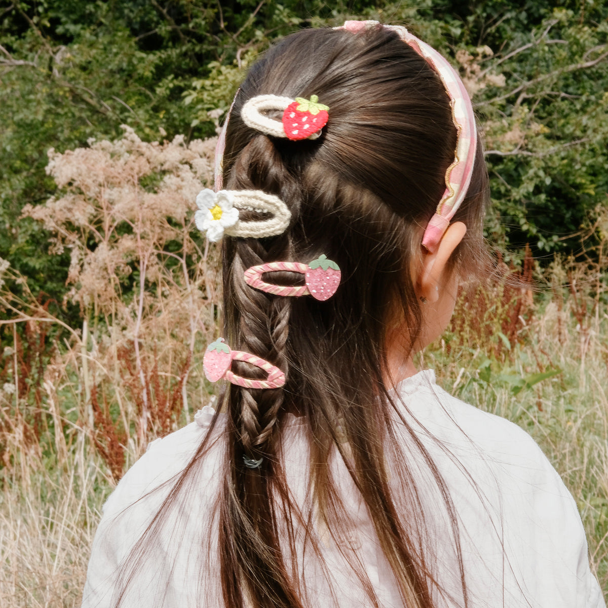 Various girls hair clips by Rockhula worn by child with braided hair.