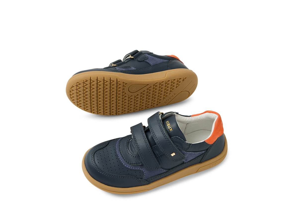 A pair of boys casual shoes by Bobux , style Hunter, in blue and orange with double velcro fastening. Above view showing top and sole of the shoes.
