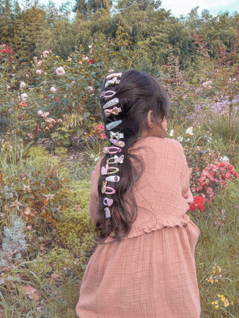 Set of colourful hair clips by Rockahula shown on back of child's long hair.