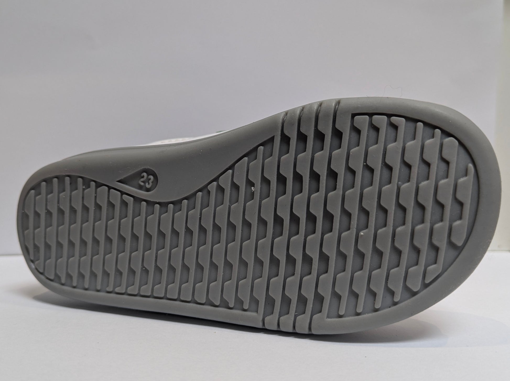 A girls casual shoe by Bobux , style I - Walk Blaze, in white with pink and blue metallic accents and grey sole. Double velcro fastening. Close up of sole.