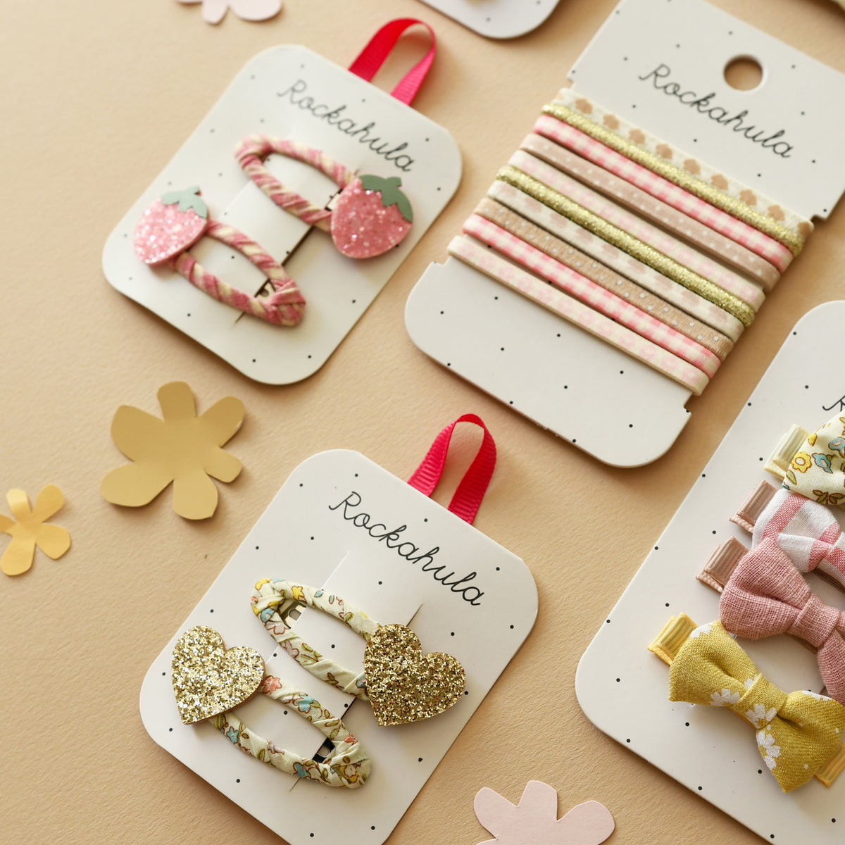 Sets of Rockahula hair accessories on branded white card on a beige background.