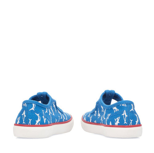A pair of boys canvas T-Bar shoes by Start Rite, style Surf, in blue with white shark print and buckle fastening. Back view.