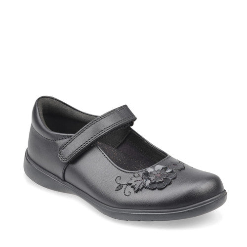 A girls Mary Jane school shoe by Start Rite, style Wish, in black leather with flower motif and velcro fastening. Angled view.