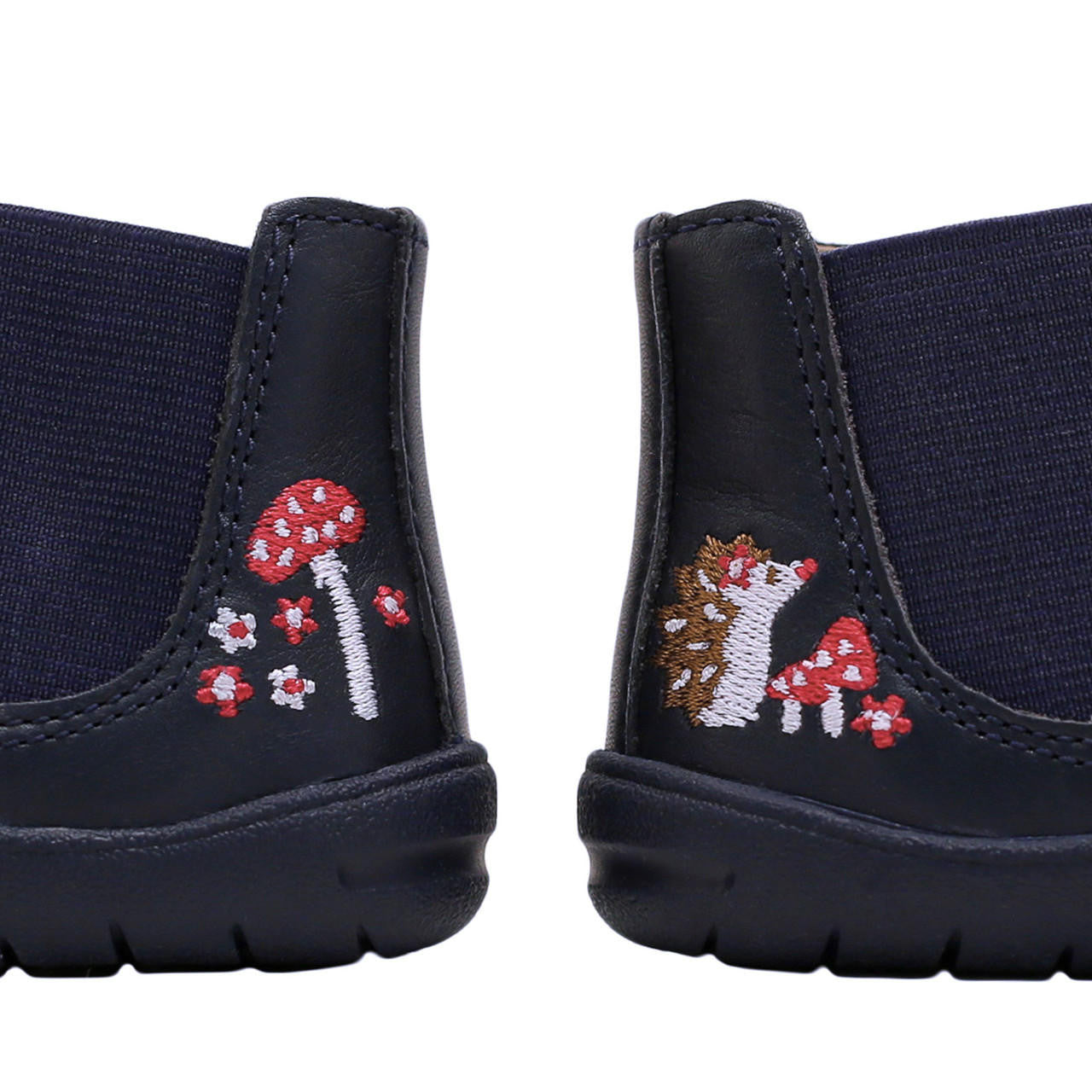 A Start-Rite + JoJo Maman Bebé girls chelsea boot in navy leather. Style is Friend with side zip fastening , heel detail shown here, toadstool on the left heel and hedgehog on the right heel.