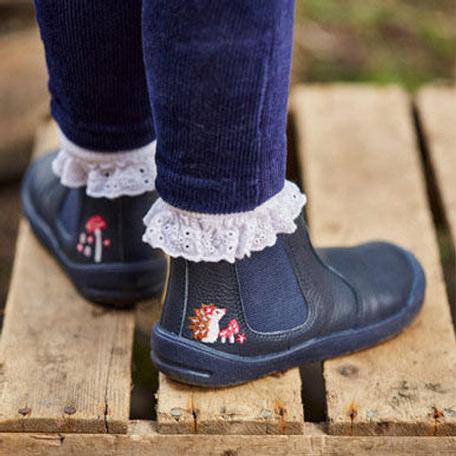 A Start-Rite + JoJo Maman Bebé girls chelsea boot in navy leather. Style is Friend with side zip fastening , the back of a pair shown here worn by a little girl..