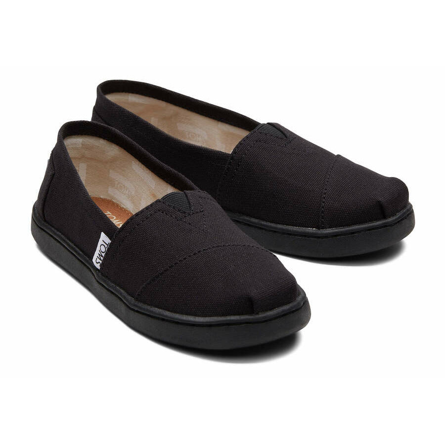A unisex canvas shoe by TOMS, style Alpargata, a slip on in black. Front view of a pair.