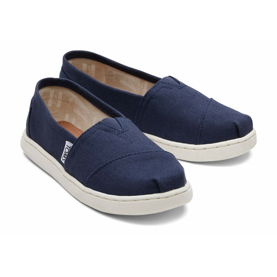 A unisex canvas shoe by TOMS, style Alpargata, a slip on in navy. Front view of a pair.