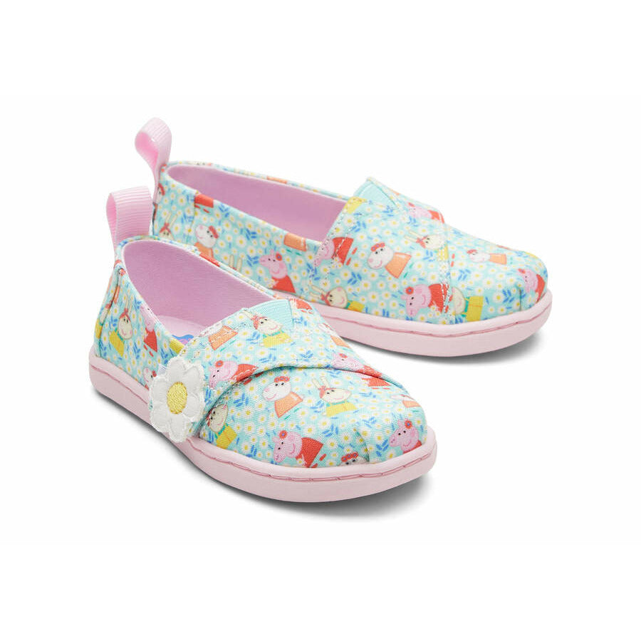 A girls canvas shoe by TOMS, style Alpargata Peppa Pig, in light jade Peppa Pig print, and a velcro strap with daisy detail. Front view of a pair.