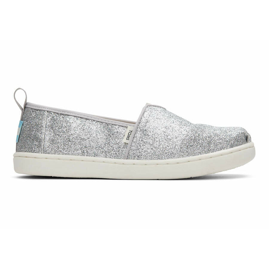 A girls canvas shoe by TOMS, style Alpargata, a slip on in silver glitter. Right side view.