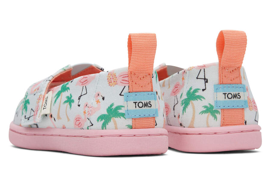 A girls canvas shoe by TOMS, style Alpargata Flamingo, in soft blue flamingo print with velcro fastening. Rear view of a pair.