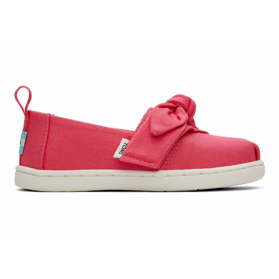 A girls canvas shoe by TOMS, style Alpargata Bow in the colour Pink Raspberry with a velcro fastening. Right side view.