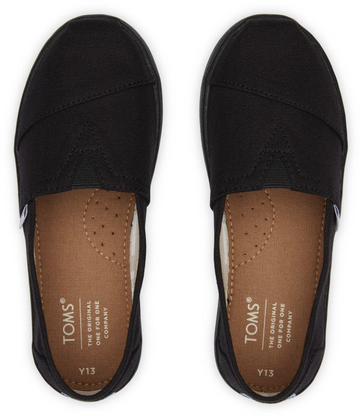 A unisex canvas shoe by TOMS, style Alpargata, a slip on in black. Top view of a pair.