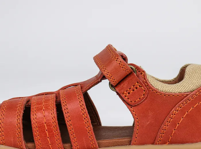 A boys closed toe sandal by Bobux,style Roam,in orange with velcro fastening. Inner side view.
