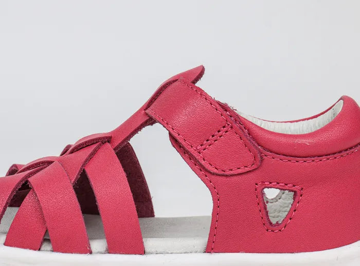 A girls open toe sandal by Bobux, style Tropicana in bright pink with velcro fastening. Inner side view.