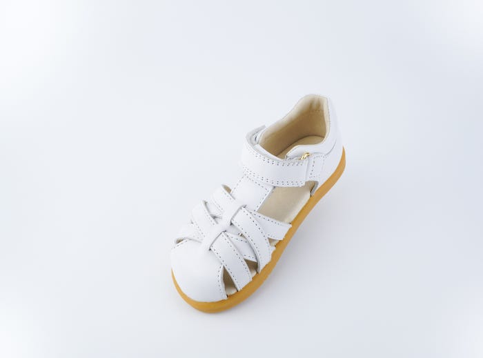 A closed toe strappy sandal by Bobux, style cross jump, in white with velcro fastening. Above view.