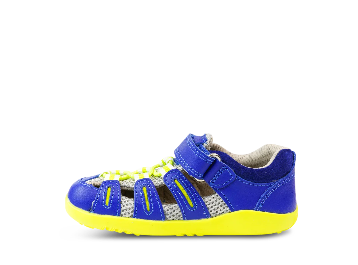 A unisex sandal by Bobux, style Summit,in blue leather/microfibre with neon yellow sole and trim and velcro/elastic fastening. Left side view.