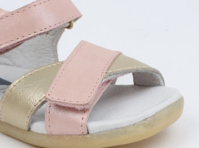 A girls open toe sandal by Bobux, style Sail, in pink and gold with velcro fastening. Close up view.