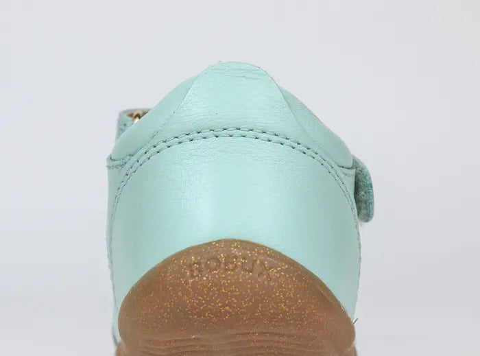 A girls open toe sandal by Bobux, style Sail, in mint and gold with velcro fastening. Back view.