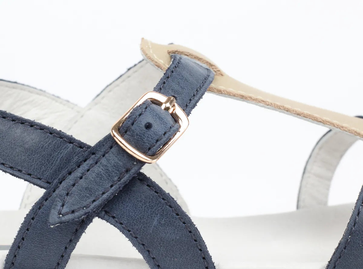 A girls open toe sandal by Bobux, style Pixie, in navy and gold with buckle fastening. Close up view.