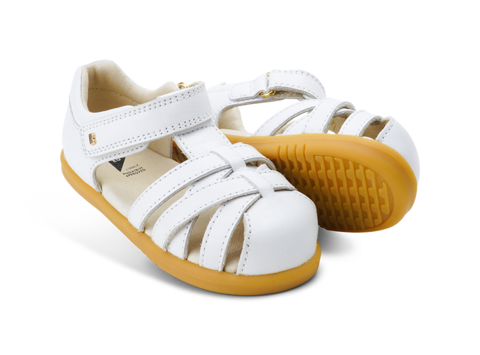 A pair of closed toe strappy sandals by Bobux, style cross jump, in white with velcro fastening. Right side view.