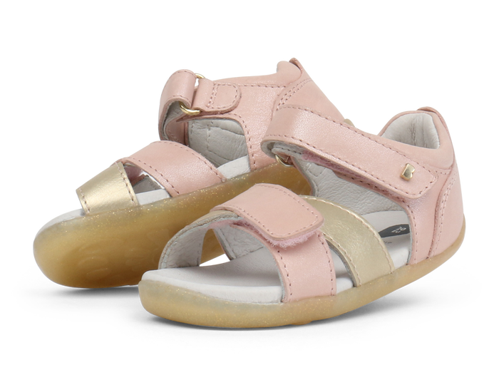 A pair of girls open toe sandals by Bobux, style Sail, in pink and gold with velcro fastening. Left side view.
