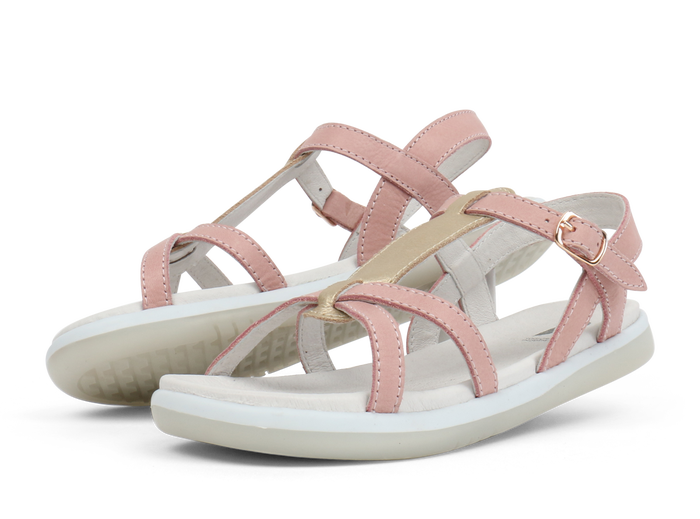 A pair of girls open toe sandals by Bobux, style Pixie, in pink and gold with buckle fastening. Left side view.