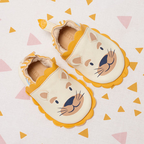 A unisex pram shoe by Start-Rite. Style is fable, a pull on in cream and yellow leather. Top view showing a pair both with the same lion head.