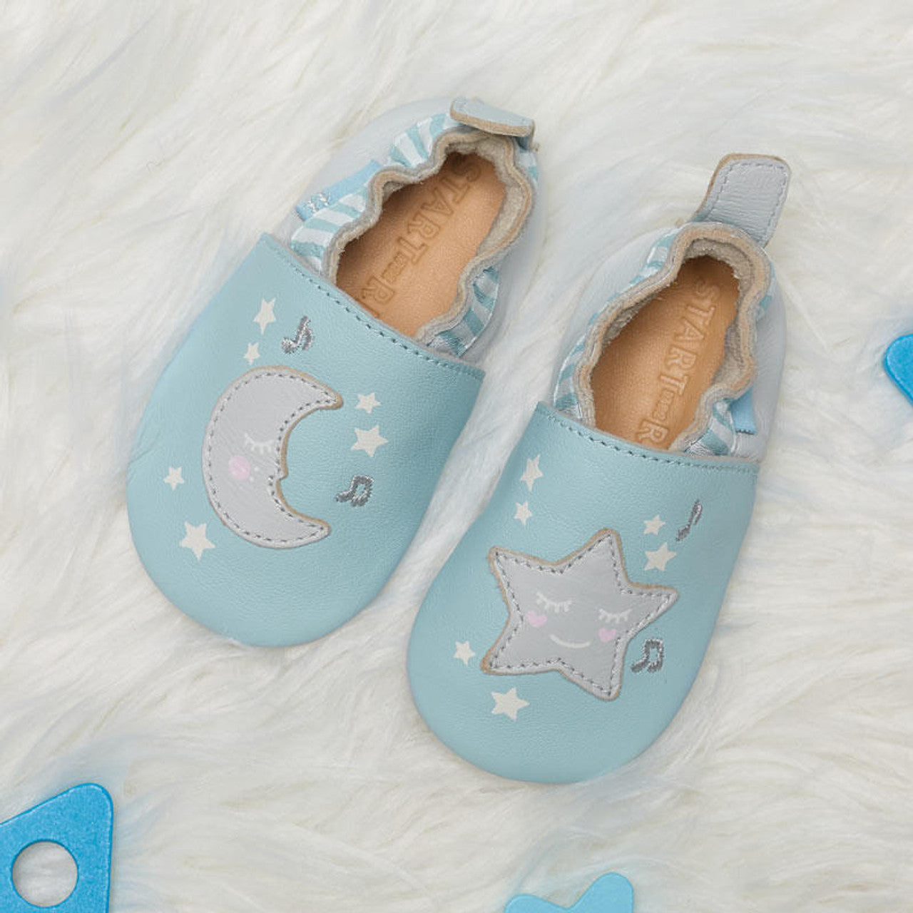 A unisex pram shoe by Start-Rite. Style is fable, a pull on in pale blue leather. Top view showing the  moon on the right and start on the left.