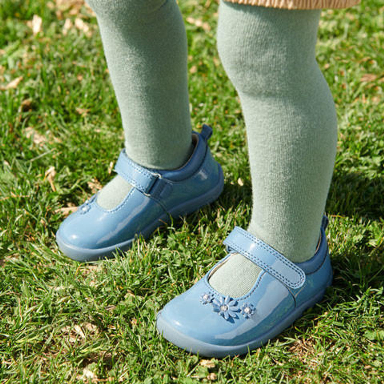 A child wearing a pair of girls Mary Jane shoes by Start Rite, style Fairy Tale, in pale blue patent with velcro fastening.