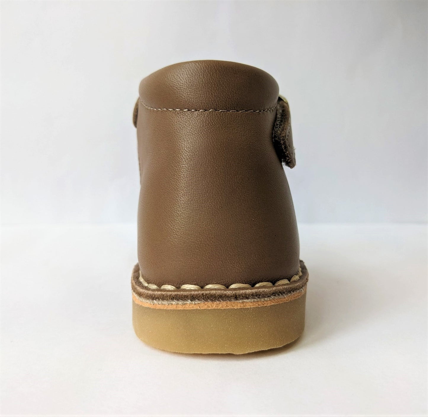 A girls T-Bar shoe by Petasil, style Cooper, in light brown with faux buckle fastening.Back view.