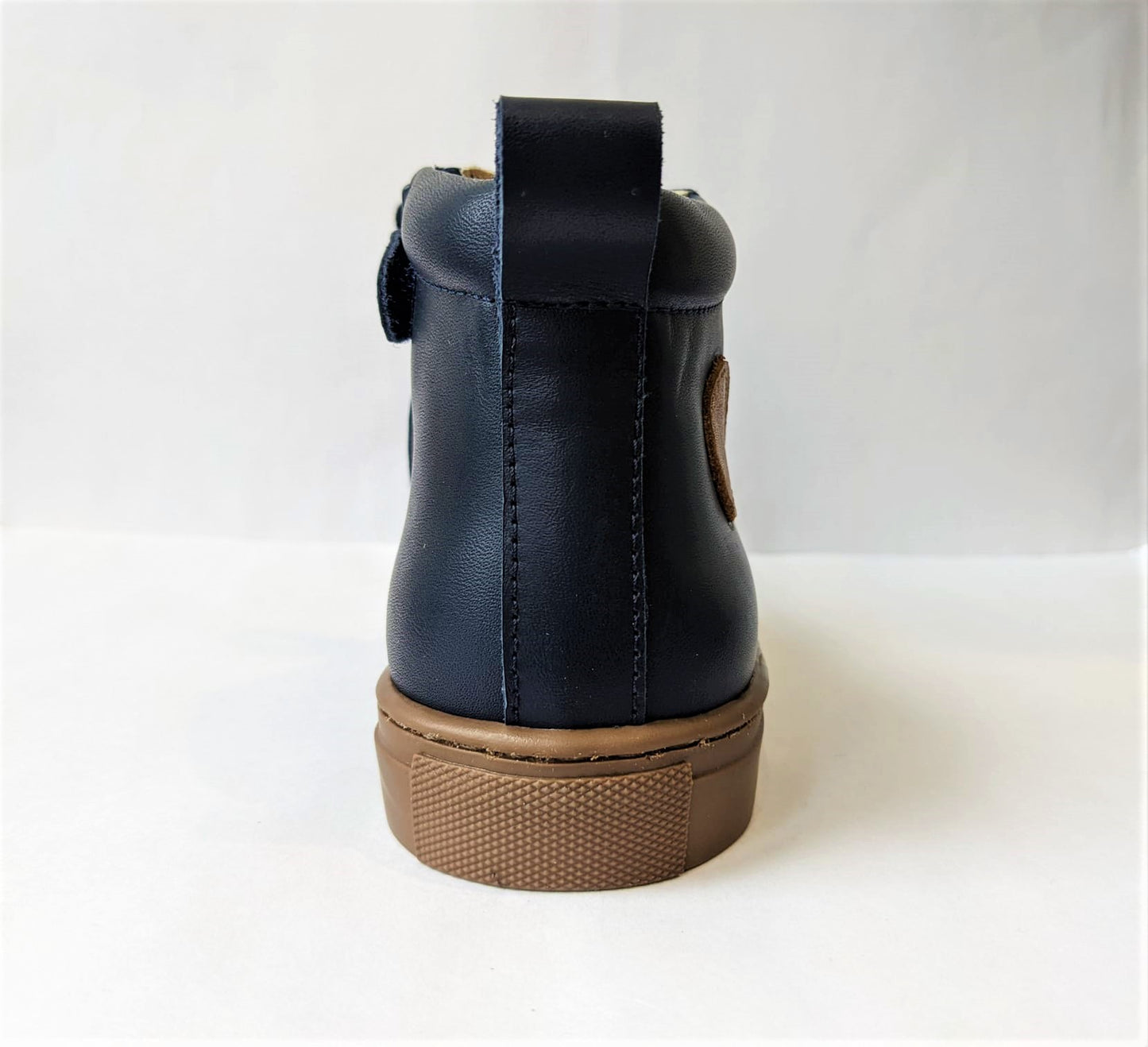 A boys boot by Petasil, style Esme, in navy with lace and side zip fastening. Back view.