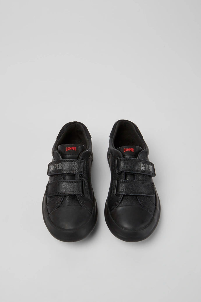 A pair of boys casual school shoes by Camper, style K800415-001,in black leather with double velcro fastening. Above front view.
