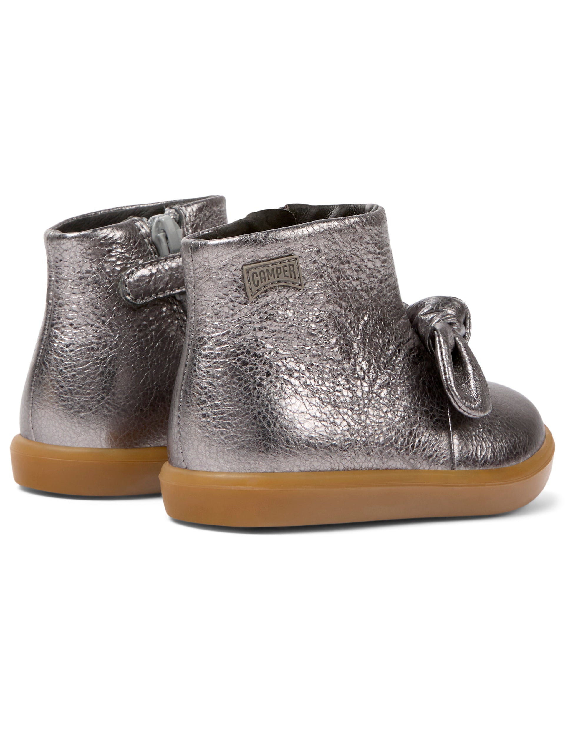 A pair of girls ankle boots by Camper, style K900267-006 in dark silver with bow front and zip fastening. Angled view.,