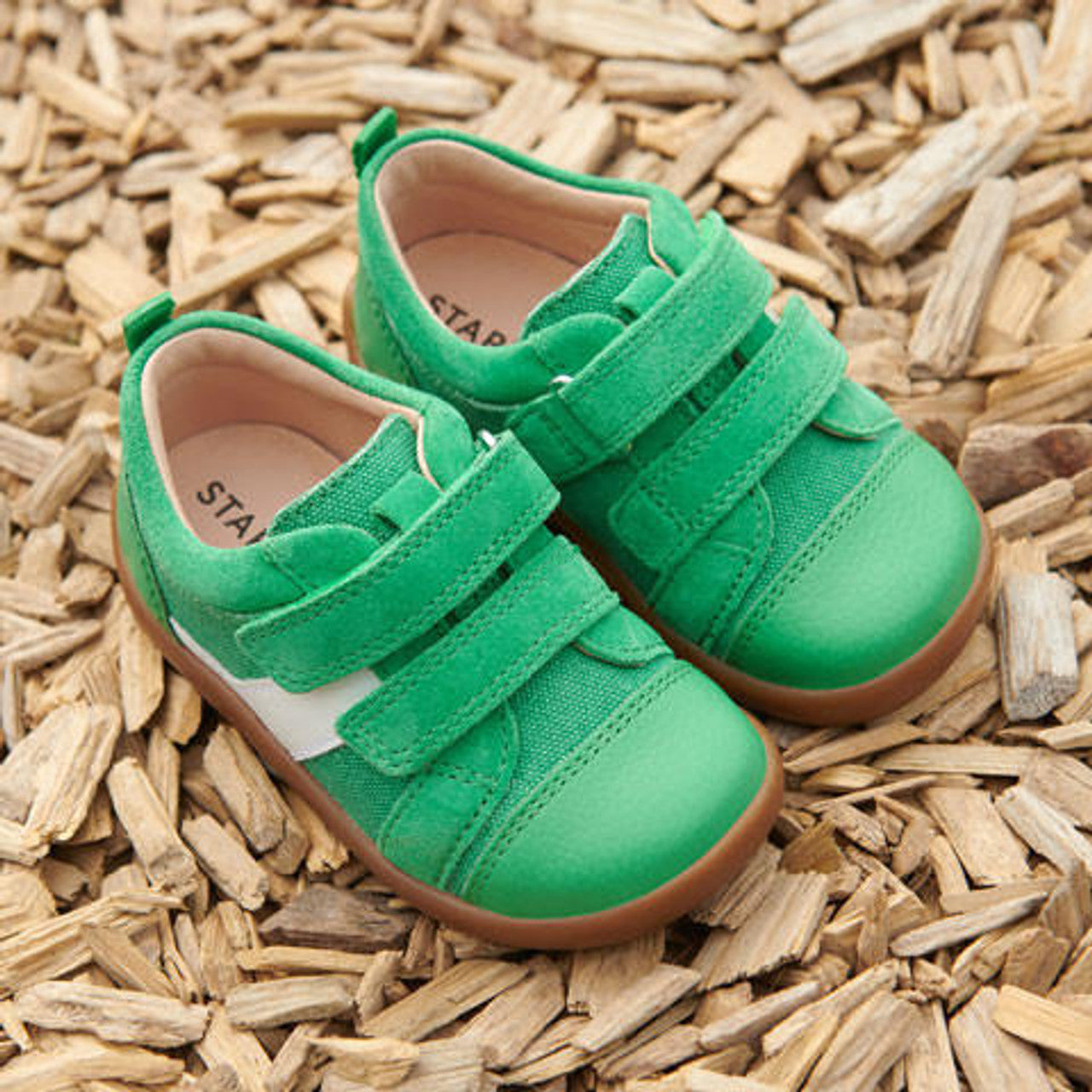 A pair of boys casual shoes by Start Rite, style Maze, in green and white with double velcro fastening. Angled view.