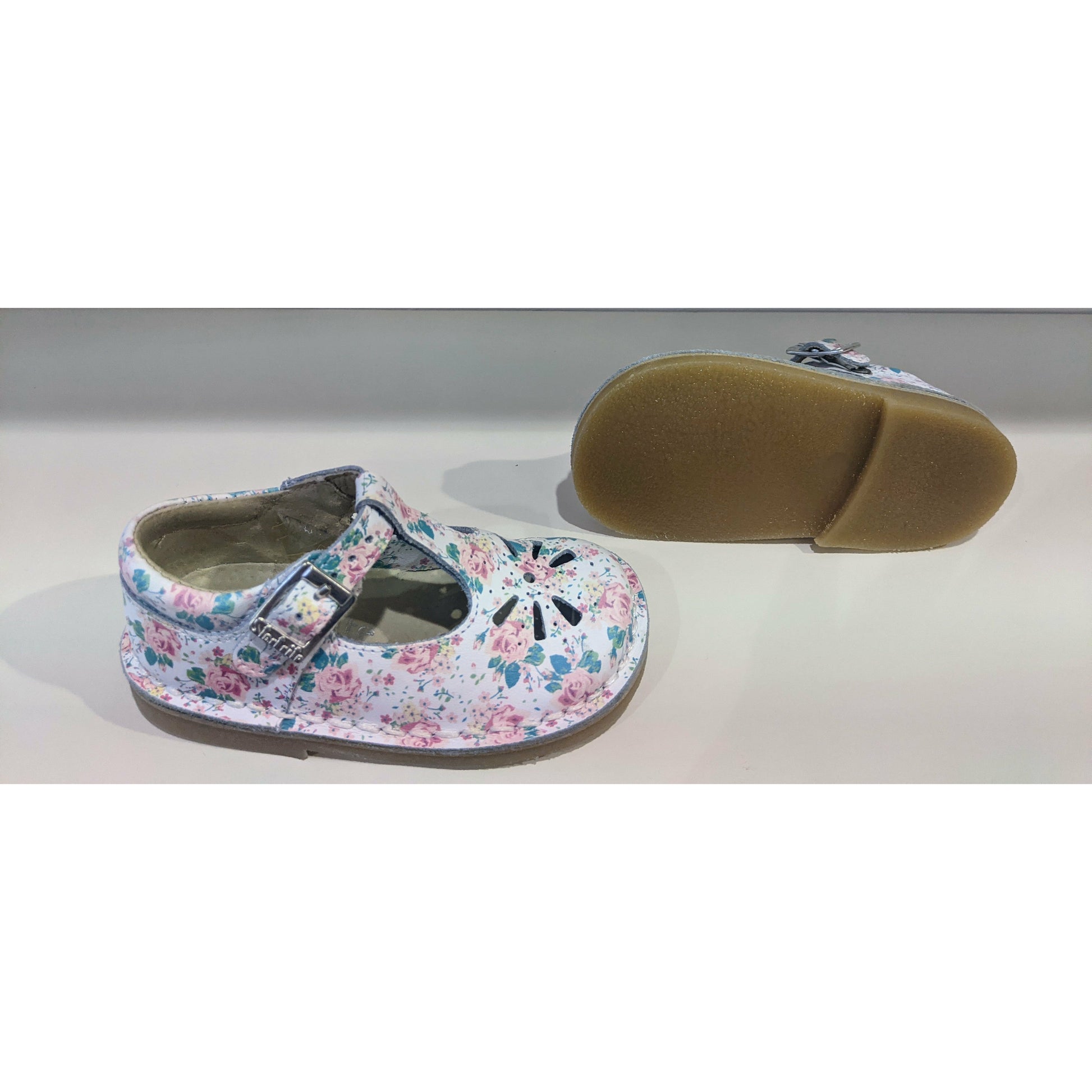 A pair of girls t-bar shoes by Start-Rite, style Lottie, in white floral leather with buckle fastening. Right side/sole view. view