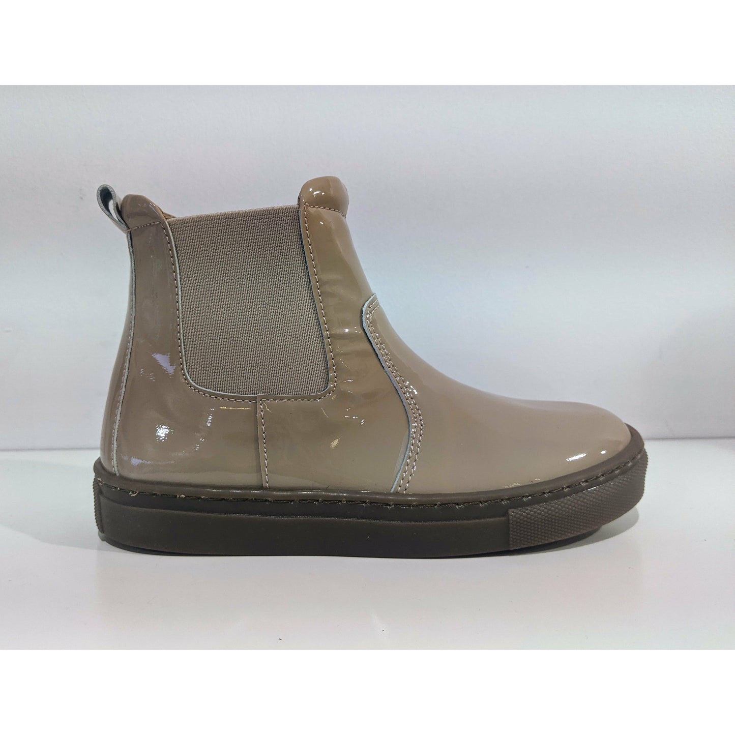 A Girls ankle boot by Petasil, style Candy, in nude patent with self coloured elastic panel, inside zip fastening. Right side view.