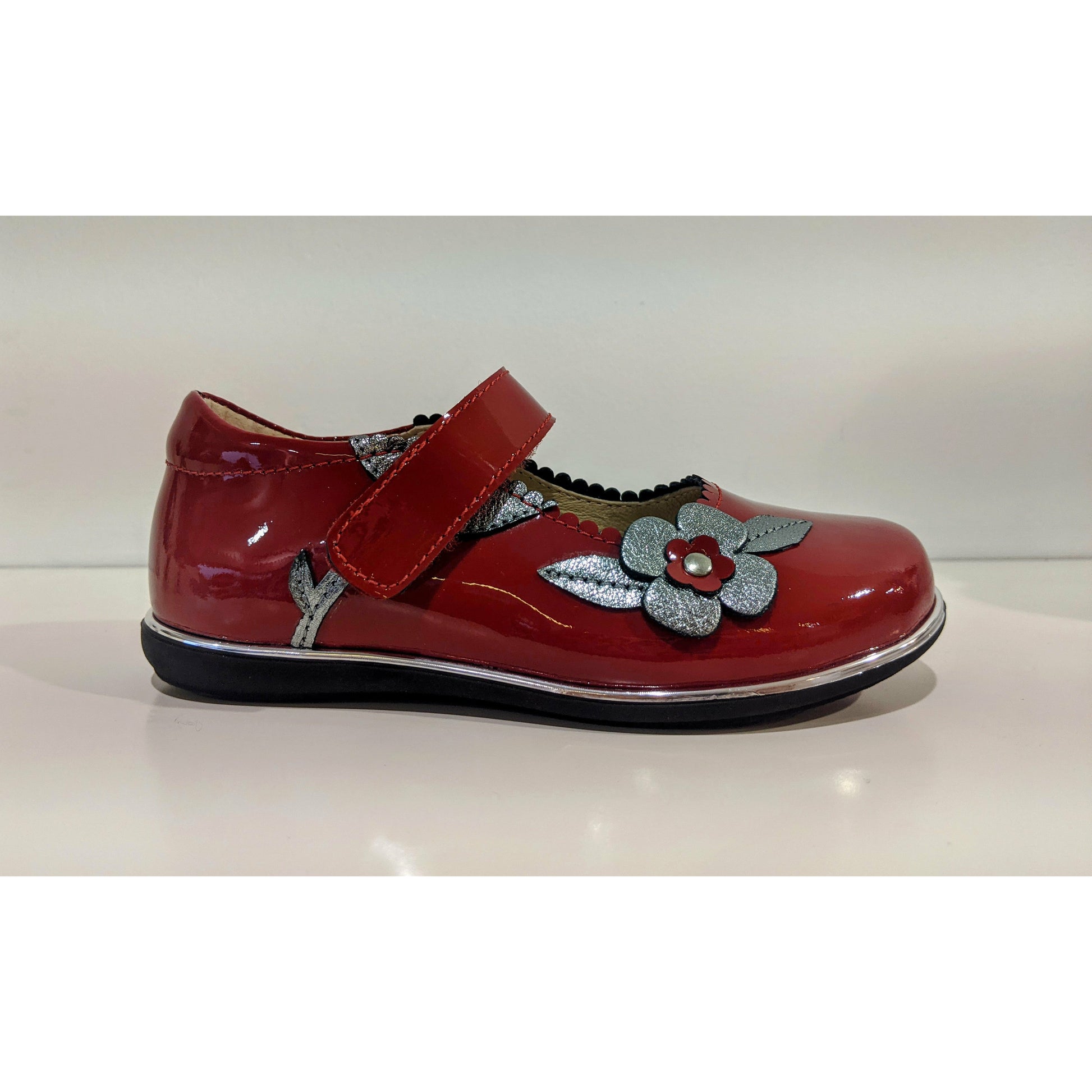 A girls Mary Jane shoe by Petasil,style Caren, in red patent and silver with velcro fastening. Right side view.