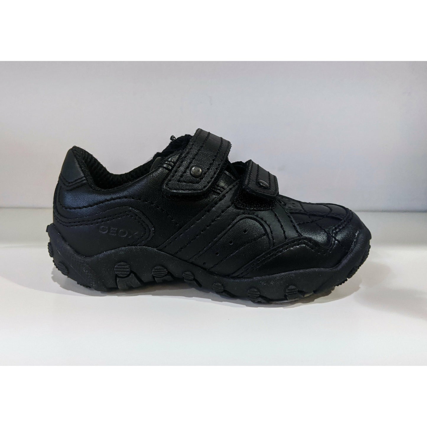 A boys casual school shoe by Geox, style Creeper, in black with double velcro fastening. Right side view.