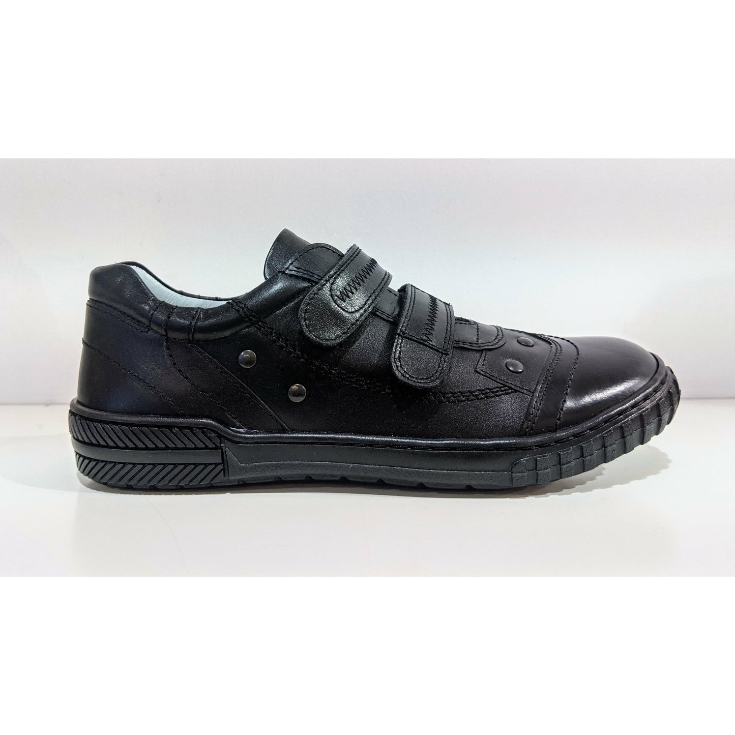 A boys school shoe by Petasil, style Gino, in black with double velcro fastening. Right side view.