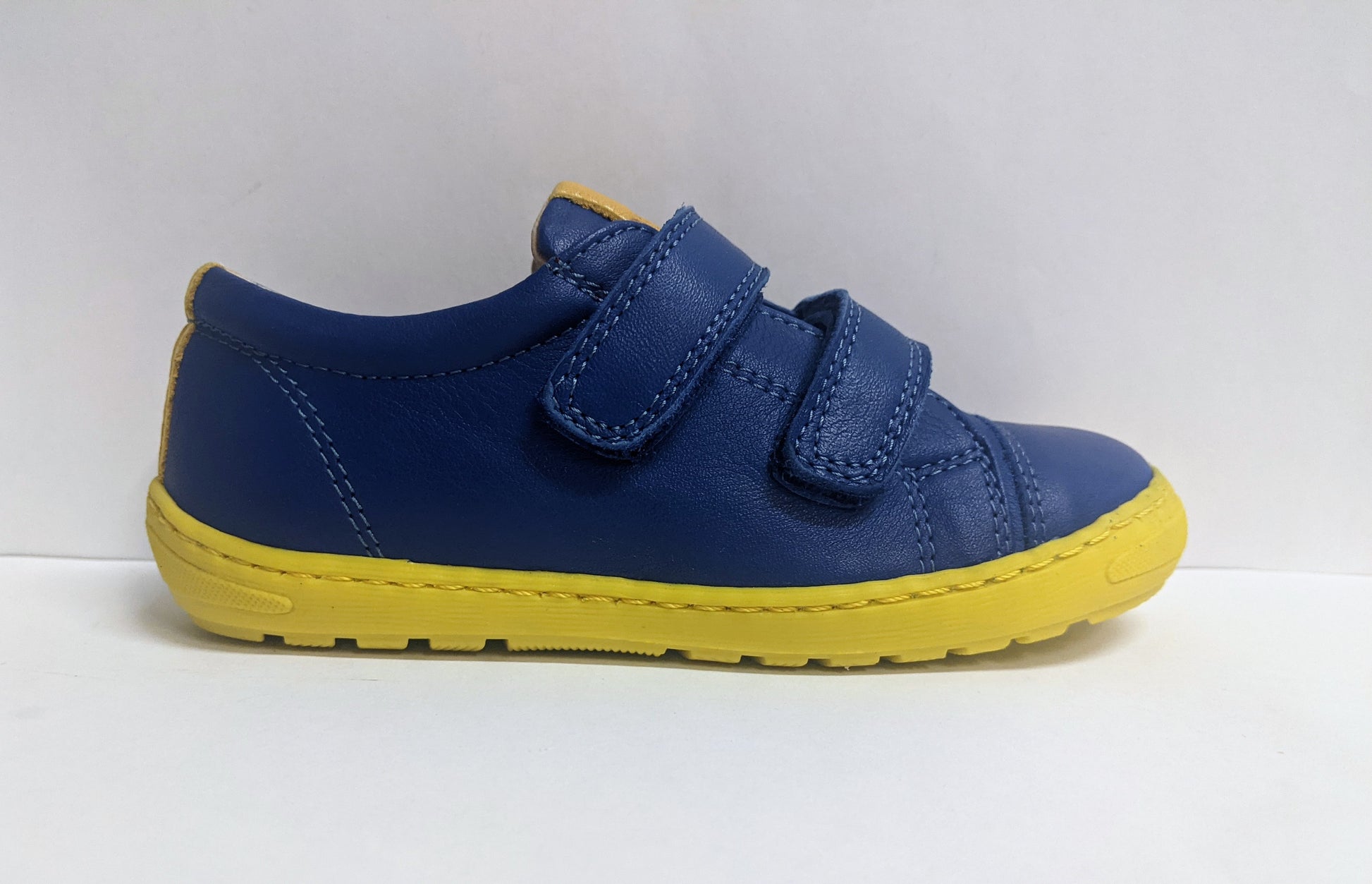 A boys casual trainer by Petasil, style Peter, in blue and yellow with double velcro fastening. Right side view.