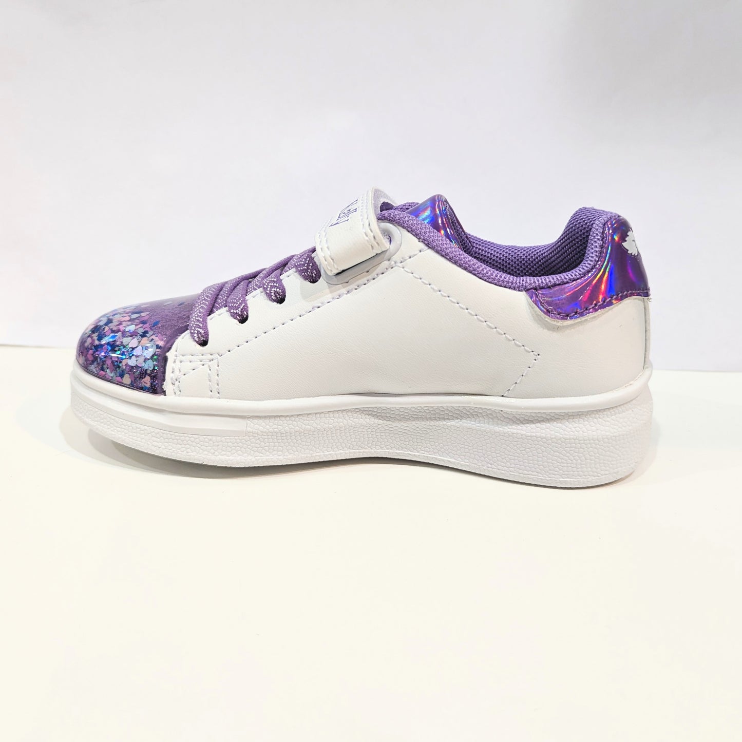 A girls casual trainer by Lelli Kelly, style Helene, in white and lilac leather with faux lace and velcro fastening.  Left side view.
