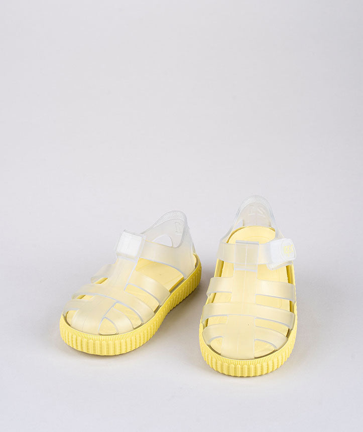 A unisex closed toe sandal by Igor, style Nico, in clear and yellow with velcro fastening. Front view.