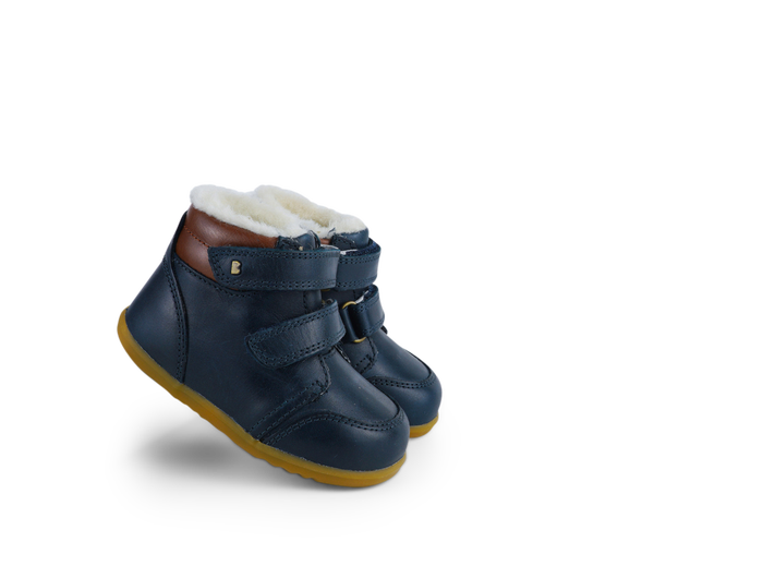 A pair of boys waterproof fur lined ankle boot by Bobux, style Timber Arctic, in Navy and tan leather with double velcro fastening. Right side view.