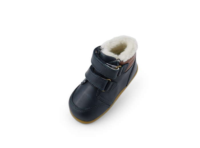 A boys waterproof fur lined ankle boot by Bobux, style Timber Arctic, in Navy and tan leather with double velcro fastening. Above view.