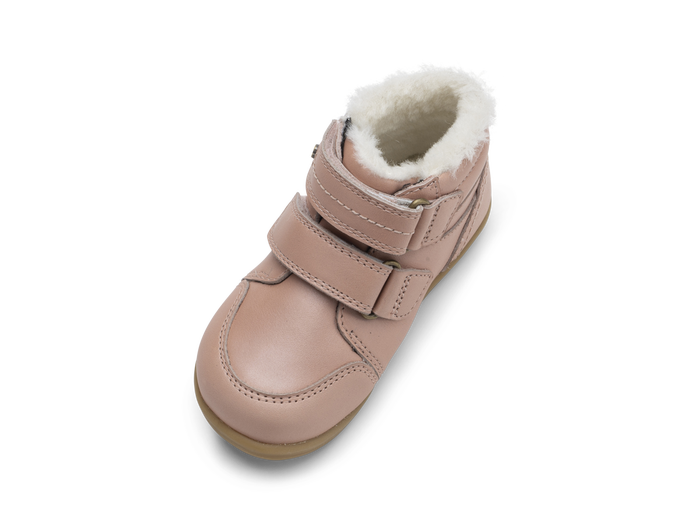 A girls waterproof fur lined ankle boot by Bobux,style Timber, in pale pink with double velcro fastening. Angled view.