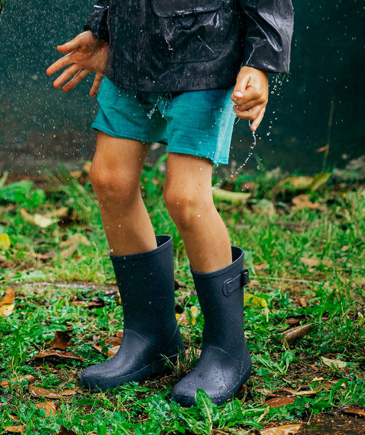 A child in a pair of unisex wellies by Igor, style Spash Euri, in Navy. Left side view.