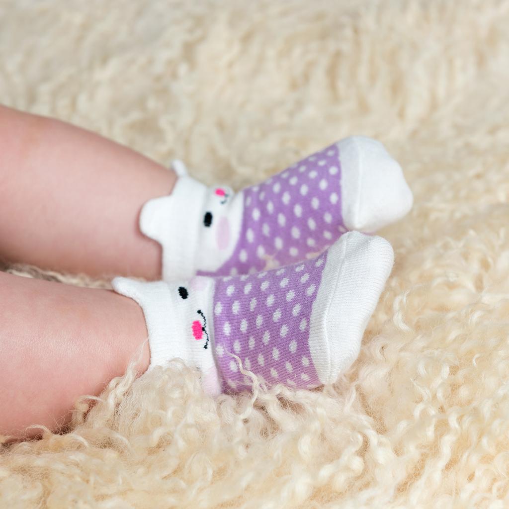 A pair of baby socks by Rex London, style Bonnie the Bunny, in lilac spot bunny design. Lifestyle image.