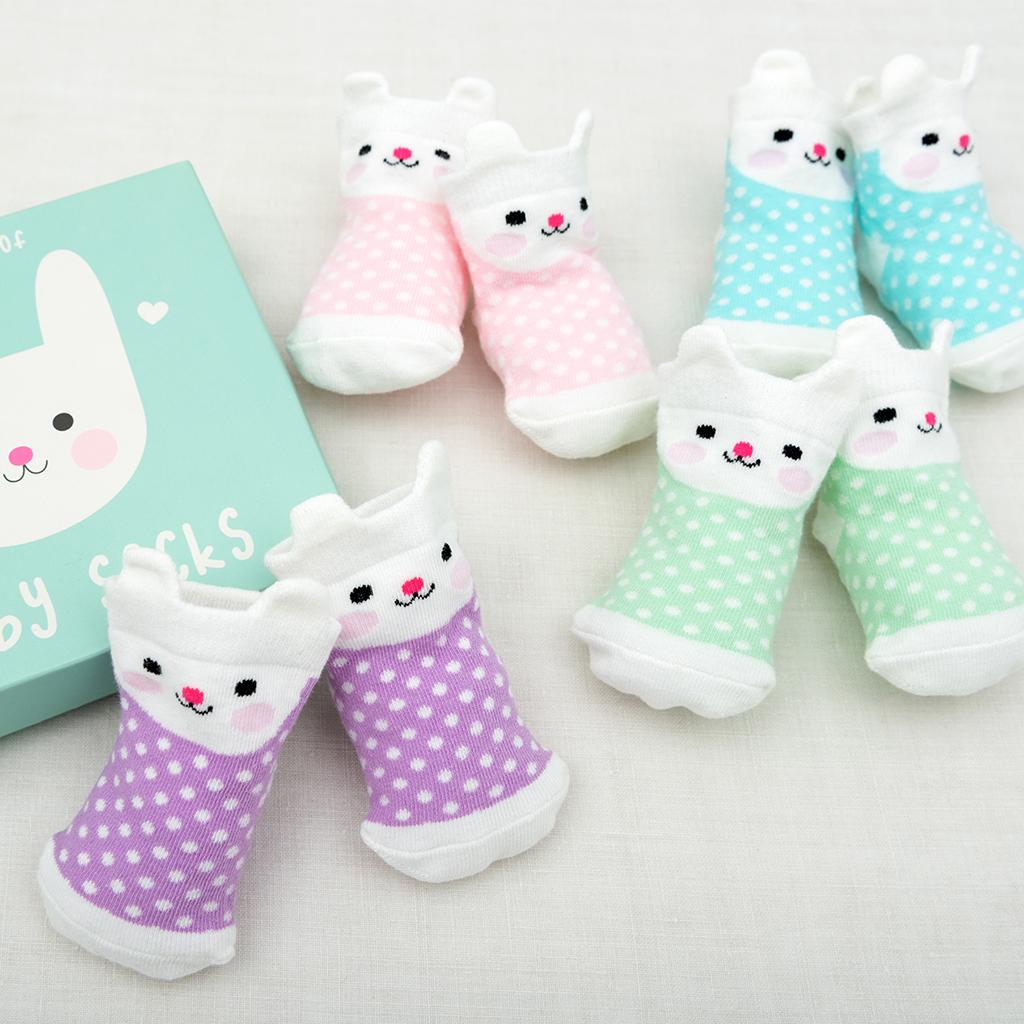 4 pairs of baby socks in a blue bunny design box by Rex London, style Bonnie the Bunny, in blue, green ,lilac, and pink spot bunny design. View of socks in pairs.
