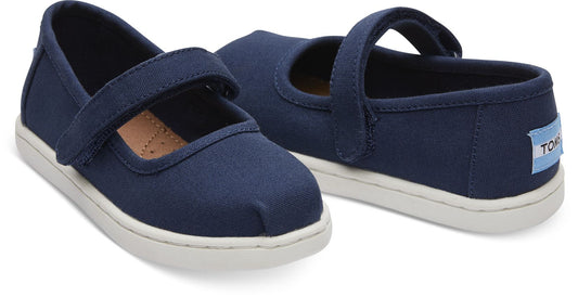 A girls canvas shoe by TOMS, style Alpargata Mary Jane, in navy denim with a velcro strap. Front and back view of a pair.